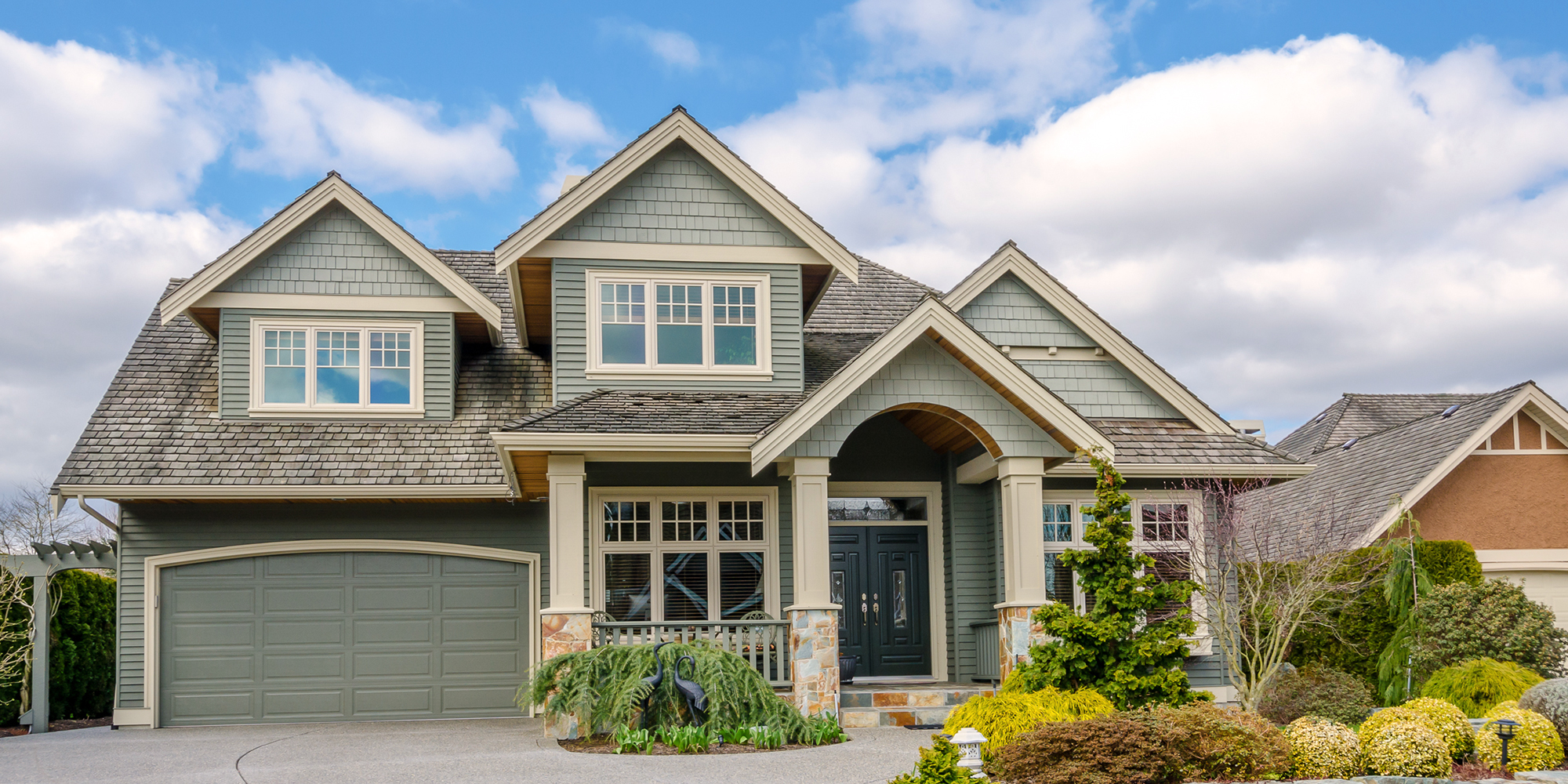 Mid-class, two-story green home with a cedar shake roof